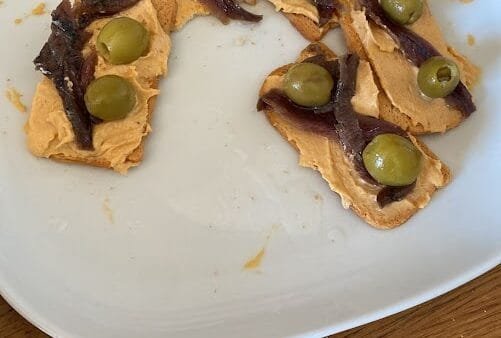 Bocados sabrosos de hummus de anchoas y aceitunas