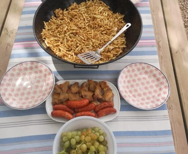 Fideuà sans gluten avec saucisses rôties et raisins