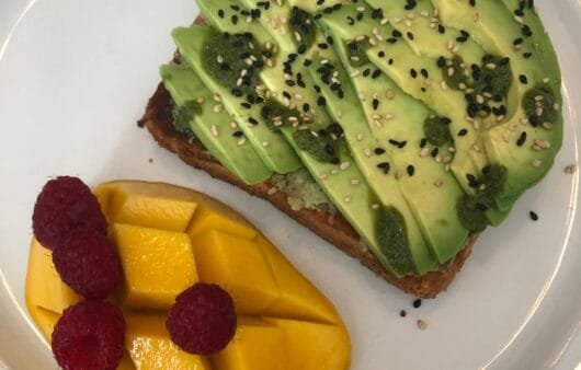 Tartine à l'avocat et au sésame avec salade de mangue et framboise