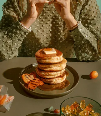 Stack of fluffy gluten-free dairy-free pancakes with butter and fruit, perfect healthy breakfast.